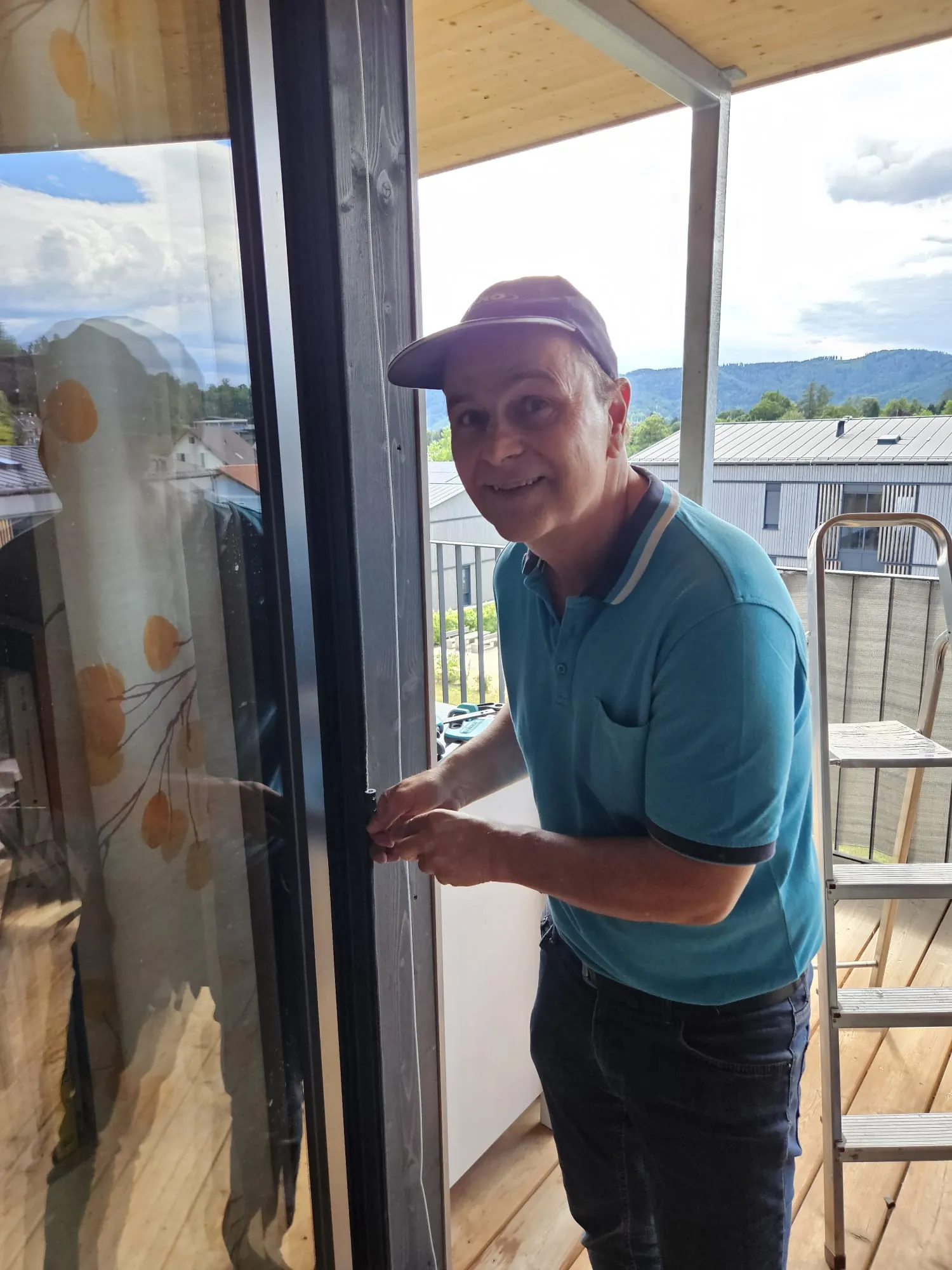 Manfred Schwab bei der Montage einer Insektenschutztuer auf einem Balkon in Graz