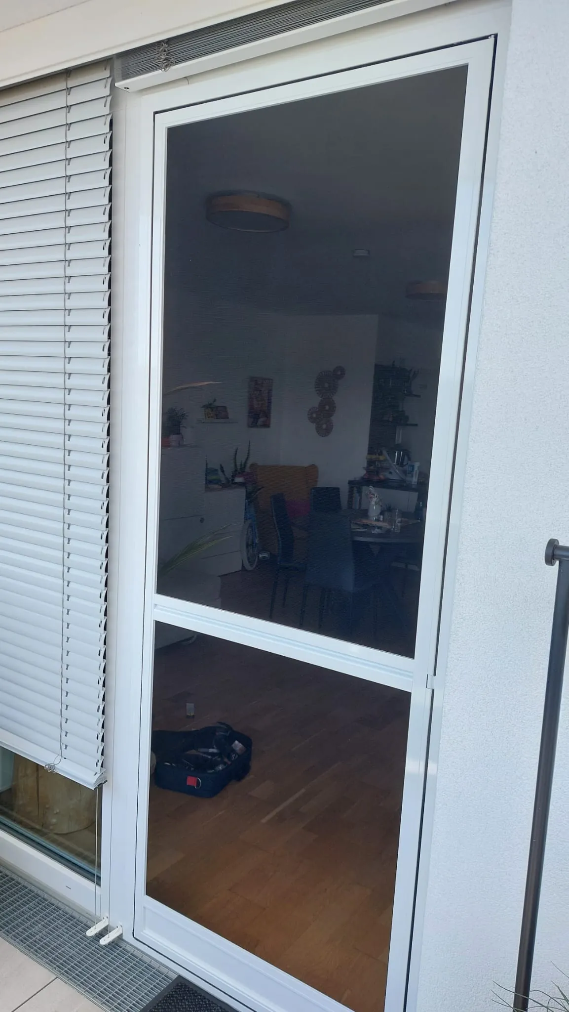 Weisse Insektenschutz-Drehtuer nach Mass an Wohnzimmer-Balkontuer in Graz